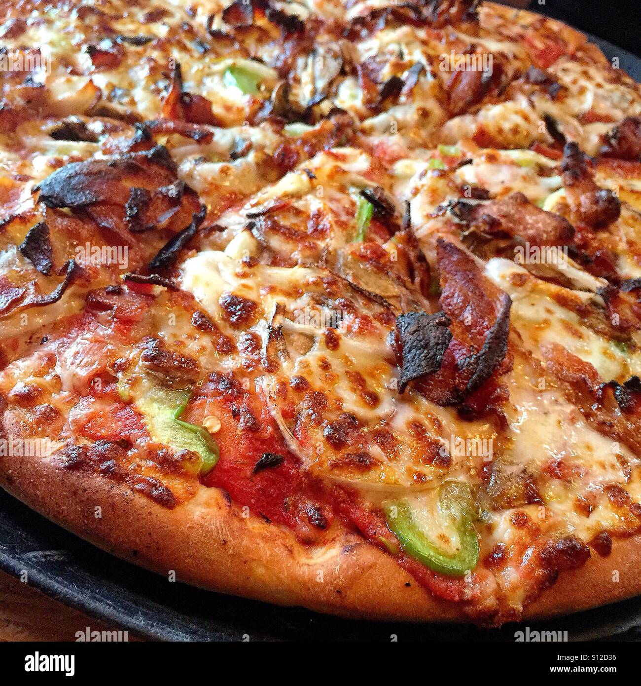 Un gros plan d'une pepperoni, bacon, poivron vert et oignon pizza Banque D'Images