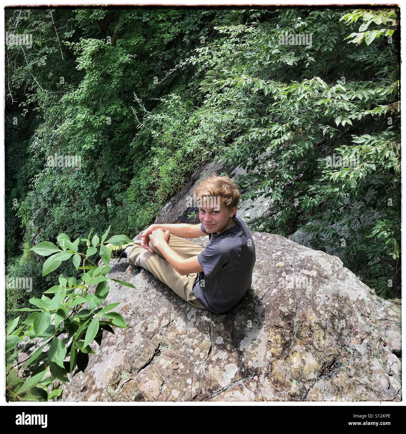 Teen boy sur une saillie rocheuse dans les montagnes Blue Ridge en Virginie Banque D'Images