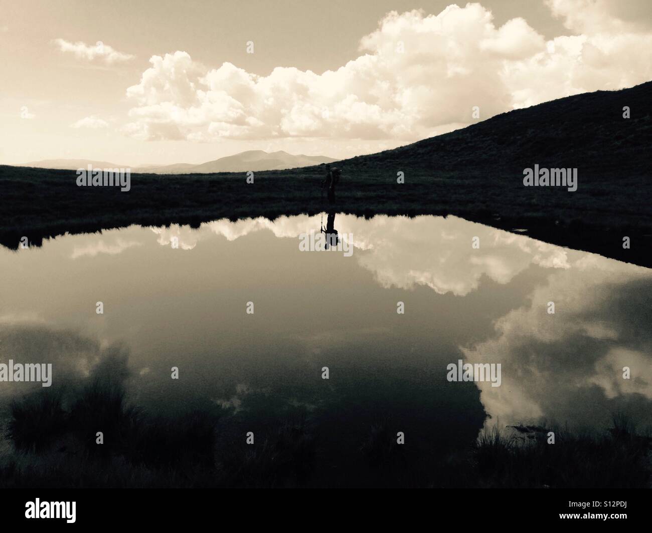 Silhouette d'un homme avec sac à dos reflétant dans le lac - Image de stock capturée avec un smartphone