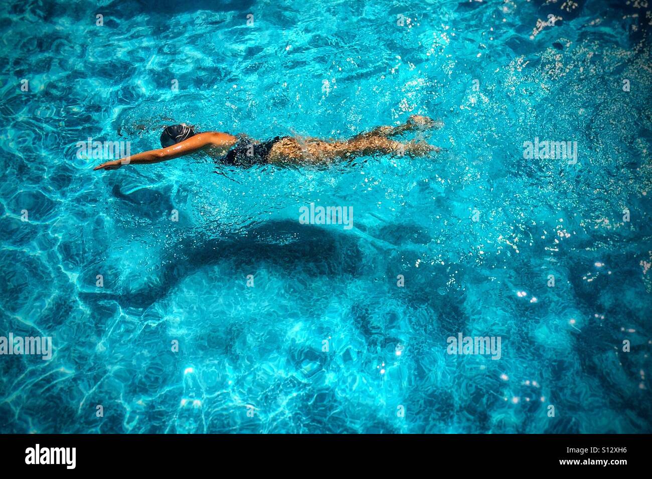 Vue en angle élevé d'une femme en forme nageant dans la piscine extérieure sur une journée ensoleillée - Image de stock capturée avec un smartphone