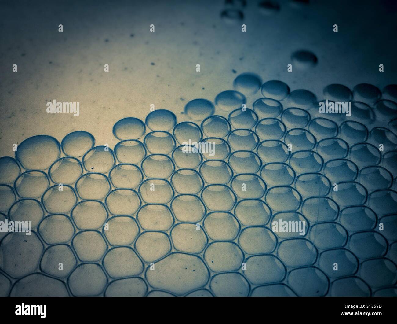 Bulles de liquide. Close up macro image de gouttelettes d'huile flottant dans l'eau couleur bleu - Image de stock capturée avec un smartphone