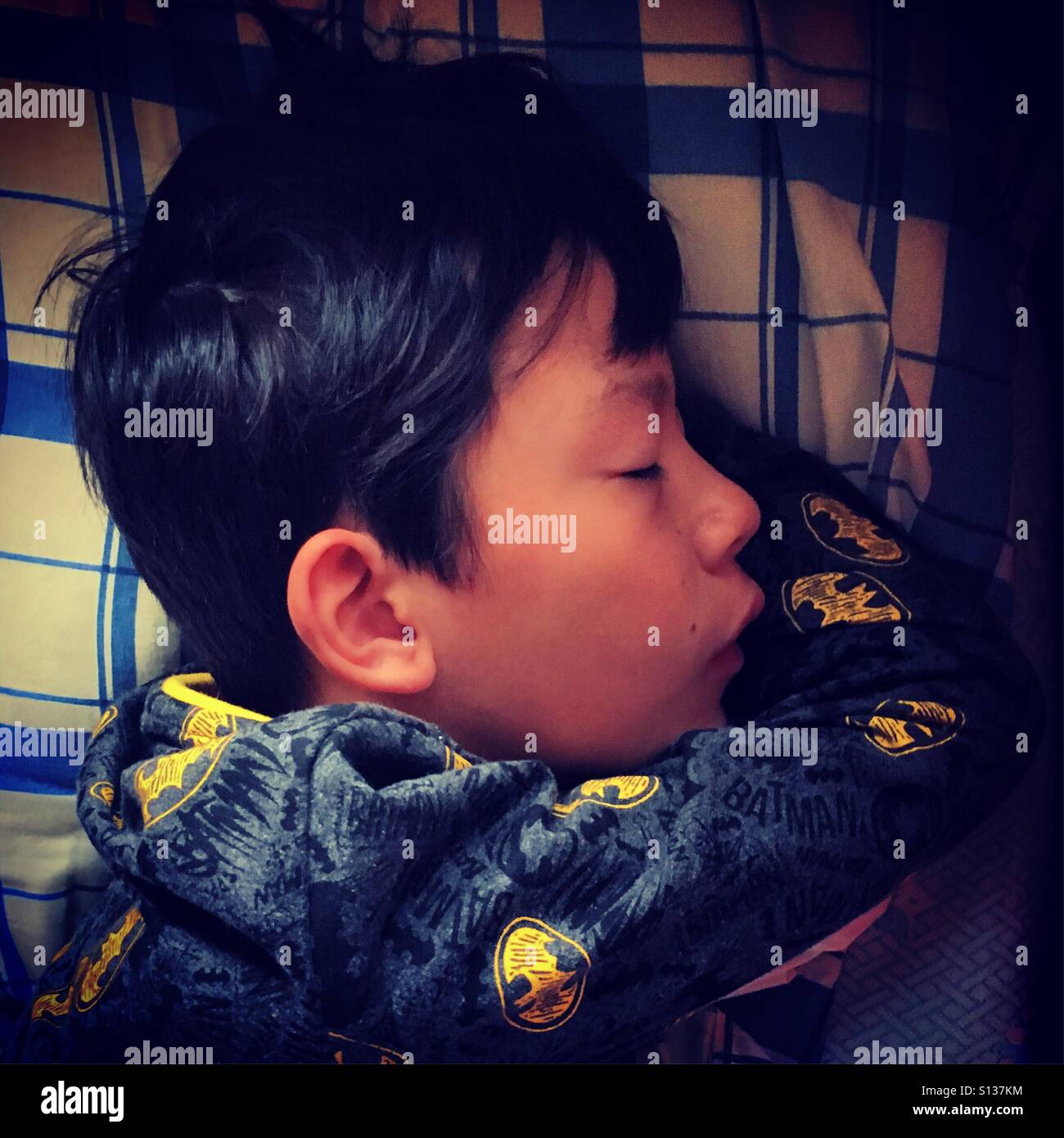 Garçon à dormir dans un lit Banque D'Images