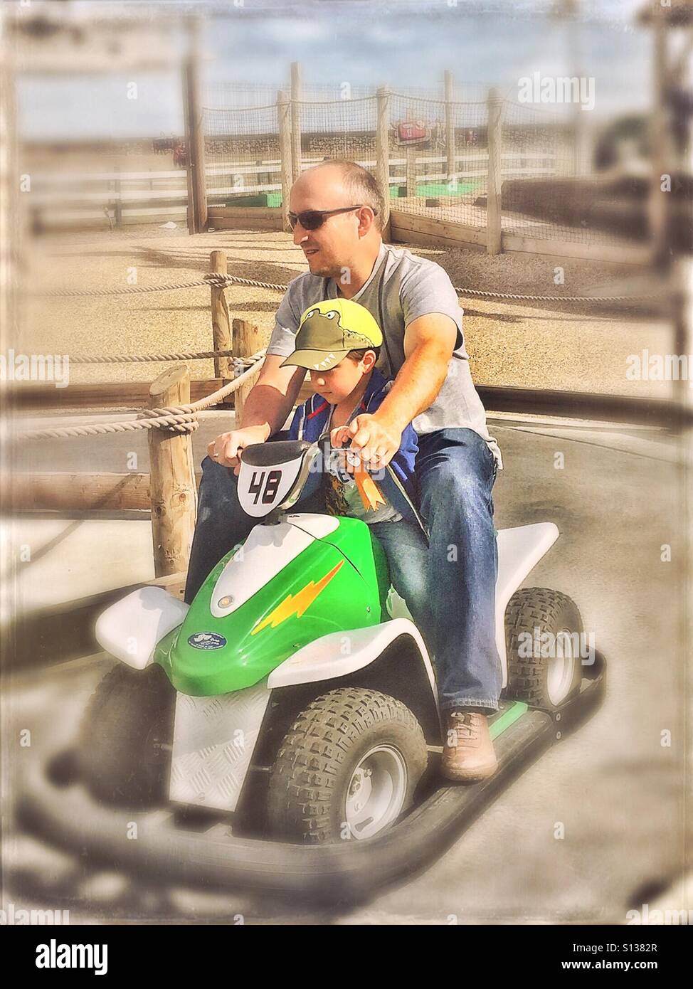 Père et fils ride une voiture exceptionnelle à un parc d'exposition. - Image de stock capturée avec un smartphone