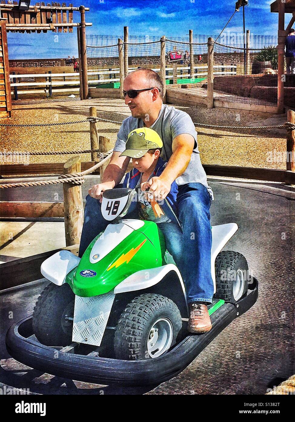 Père et fils ride une voiture exceptionnelle à un parc d'exposition. - Image de stock capturée avec un smartphone