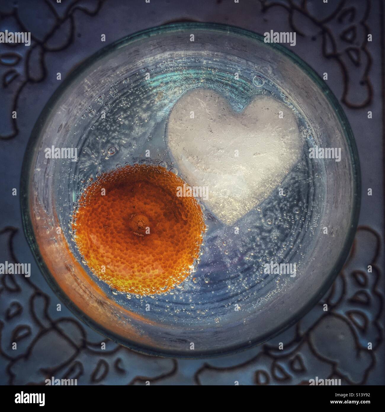 Avec verre clair, liquide, un cube de glace en forme de coeur et d'une lime. - Image de stock capturée avec un smartphone