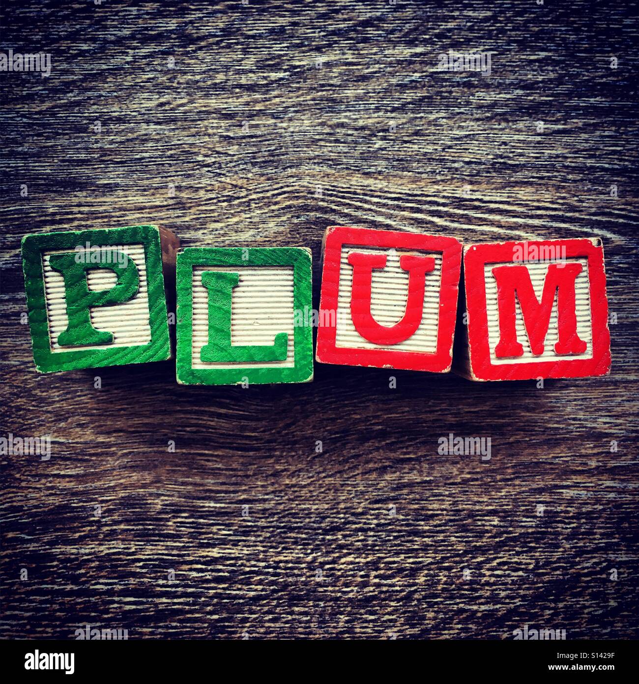 PLUM mot écrit avec une cale en bois lettre toys - Image de stock capturée avec un smartphone