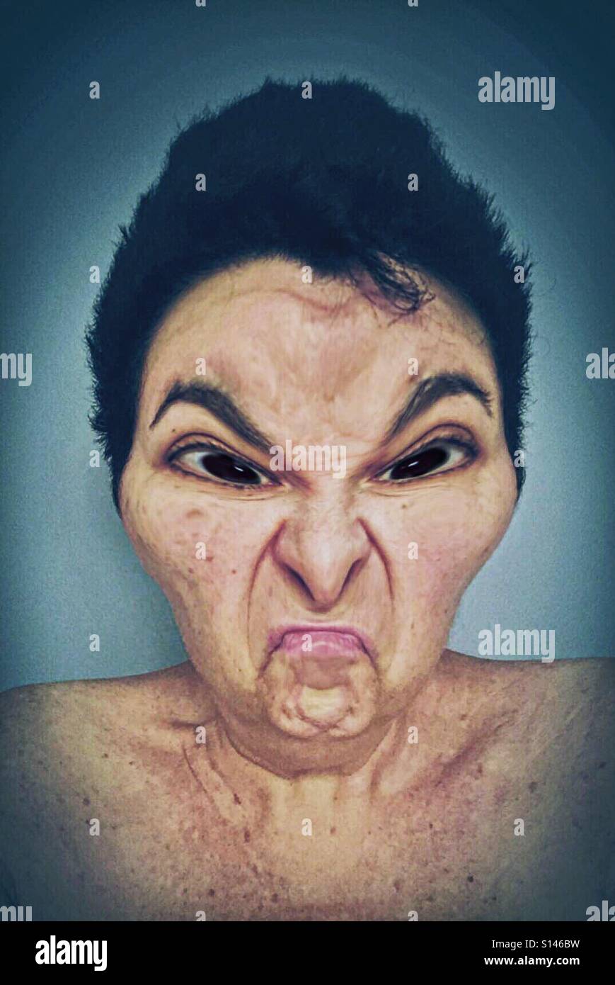 Le portrait d'une femme de race blanche aux cheveux noirs dont le visage est en colère et déformée et son look ancien. - Image de stock capturée avec un smartphone