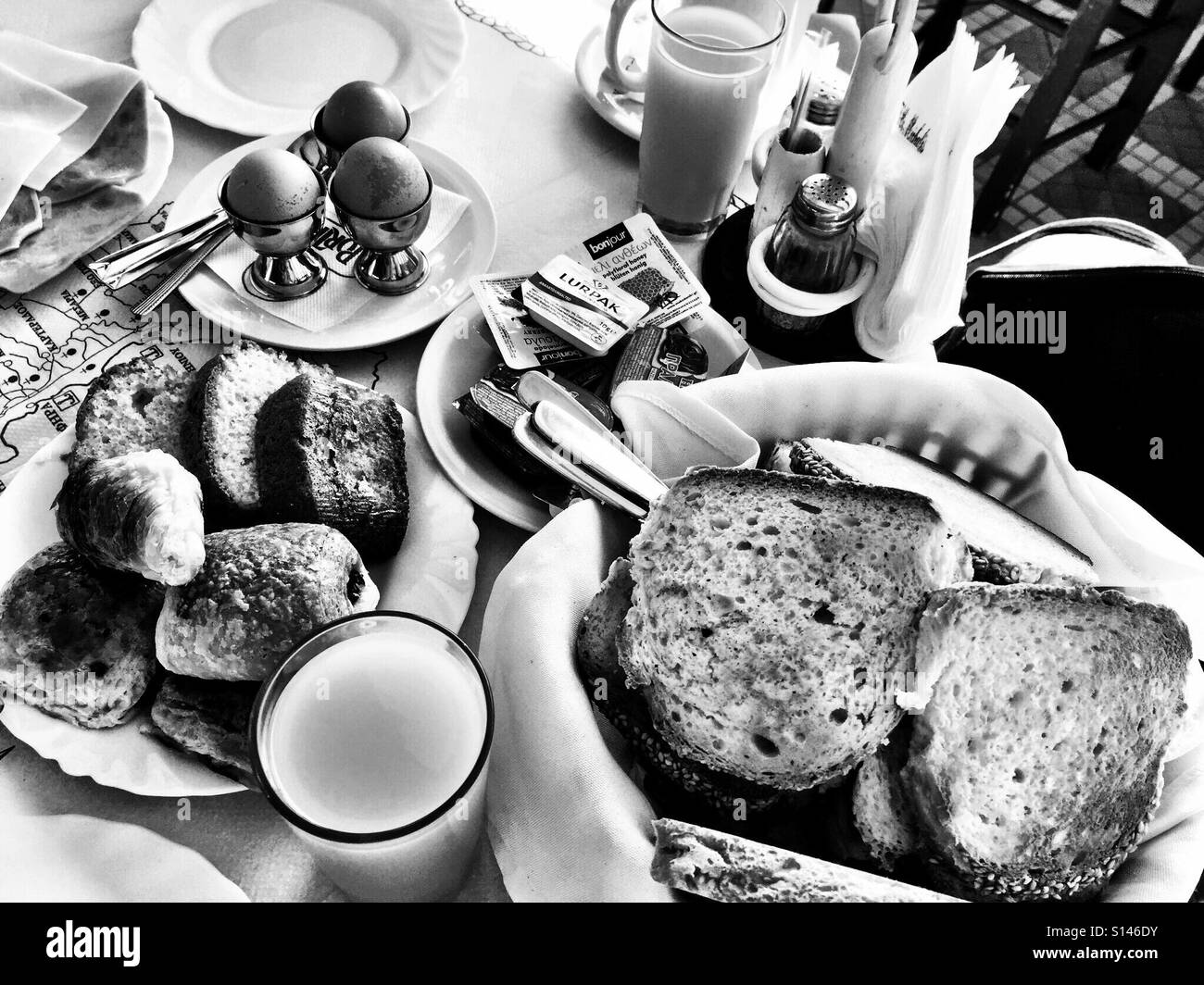 Un hôtel petit-déjeuner avec des œufs, du pain, des viennoiseries et du jus d'orange. Banque D'Images