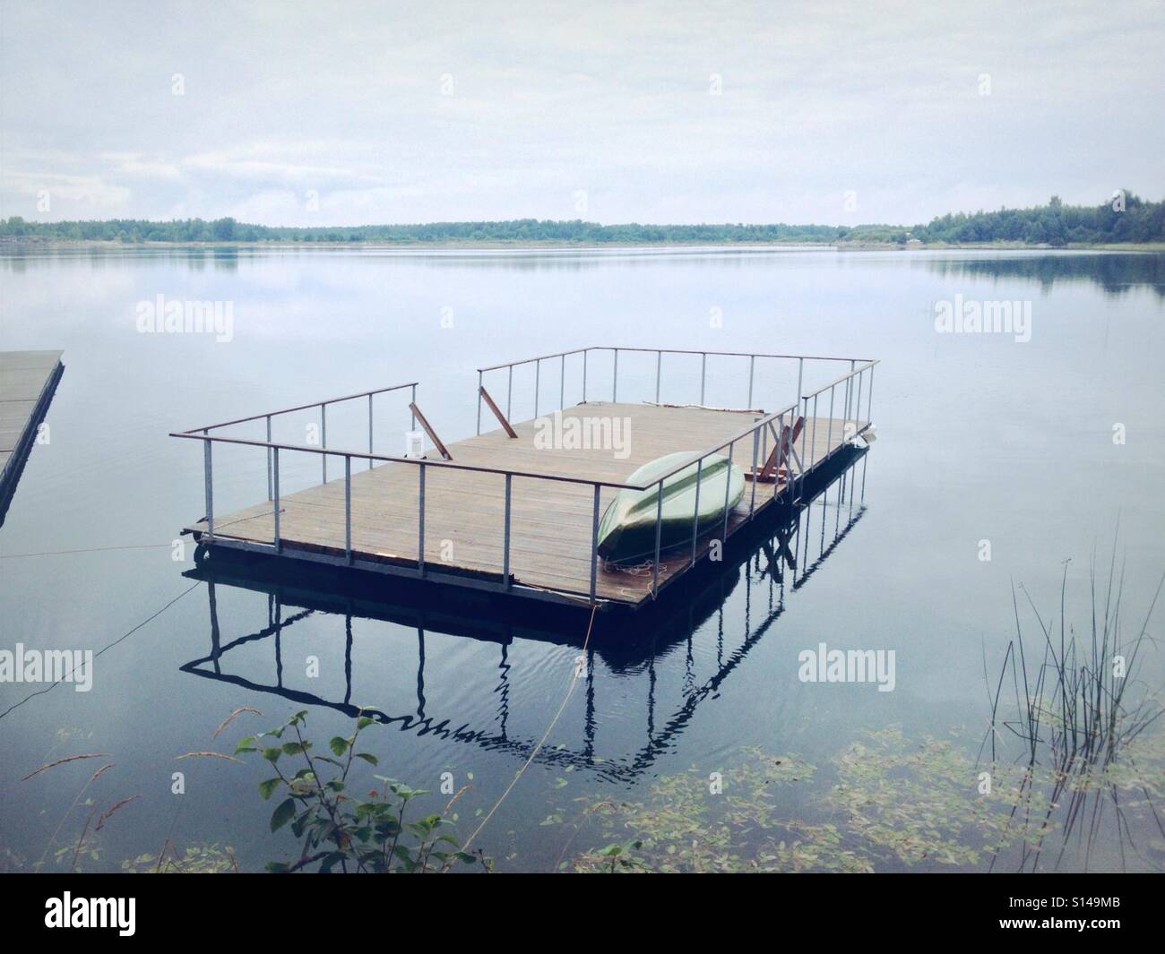 Radeau flottant sur le lac de l'eau claire avec des réflexions de miroir Banque D'Images