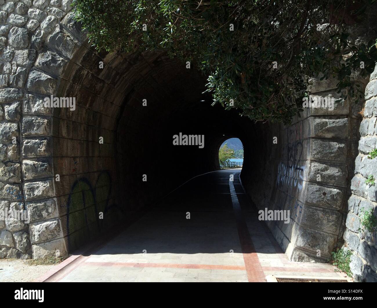 Dans le tunnel de pierre roche avec palmiers et vert dans l'autre côté de la mer Banque D'Images