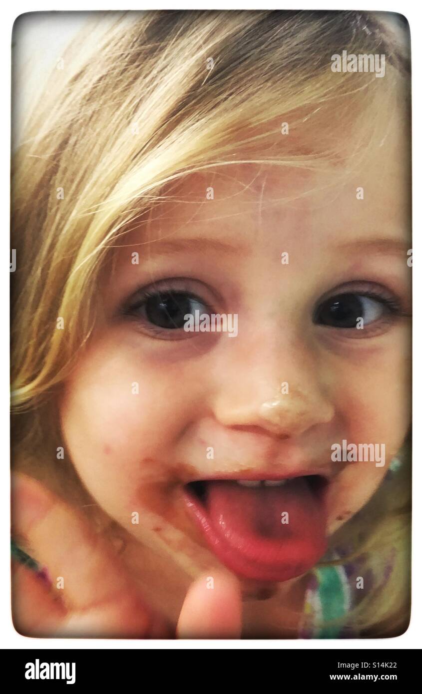 Petite fille avec de la glace crème visage prendre contact avec l'appareil photo Banque D'Images