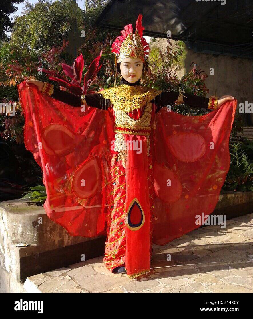 Une belle fille indonésienne affiche fièrement sa tenue traditionnelle pour un 'Peacock Dance'. Banque D'Images