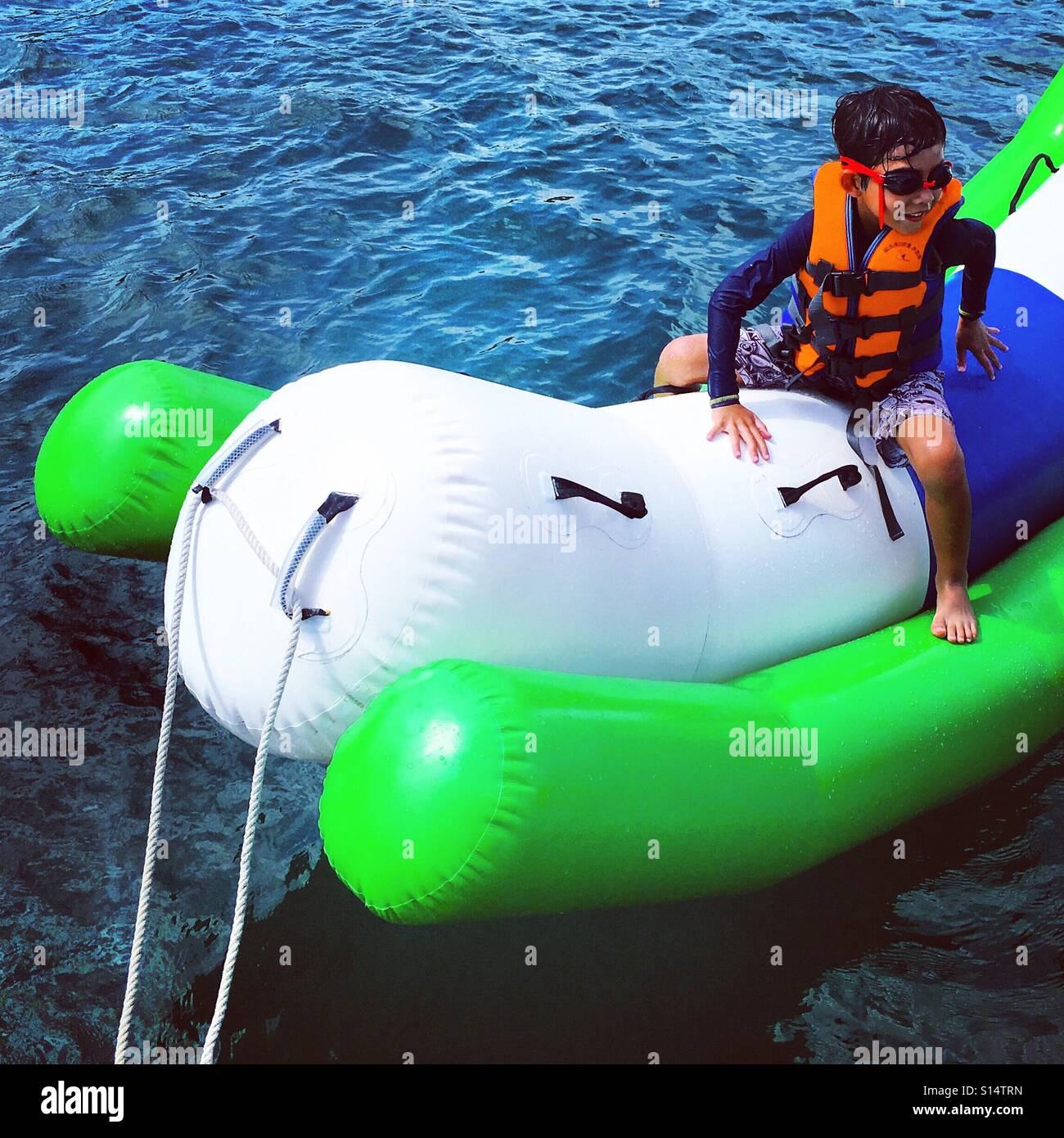 Enfant heureux jouant en banane dans la mer, activité de plein air, vacances océaniques, amusement, drôle - Image de stock capturée avec un smartphone