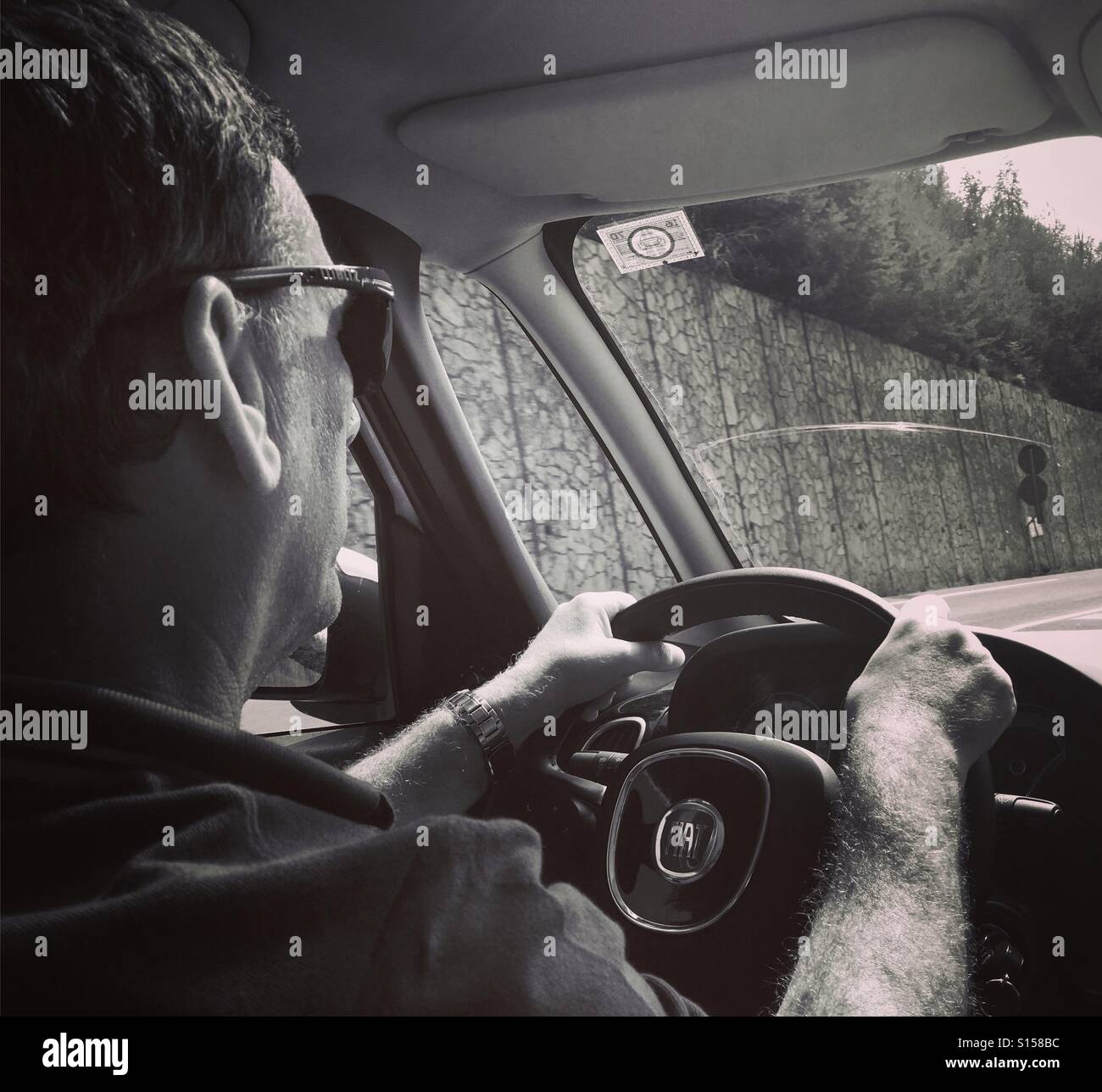 Homme au volant d'une voiture à conduite à gauche. Banque D'Images