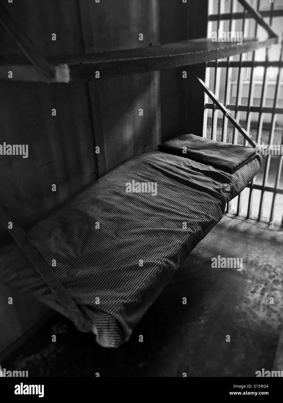 Un lit dans une ancienne cellule de prison. Banque D'Images