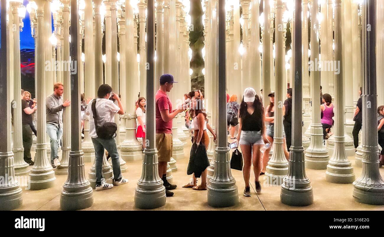 Les personnes qui se font passer à l'intérieur, ou l'errance à travers l'installation de l'éclairage urbain emblématique au LACMA. Banque D'Images