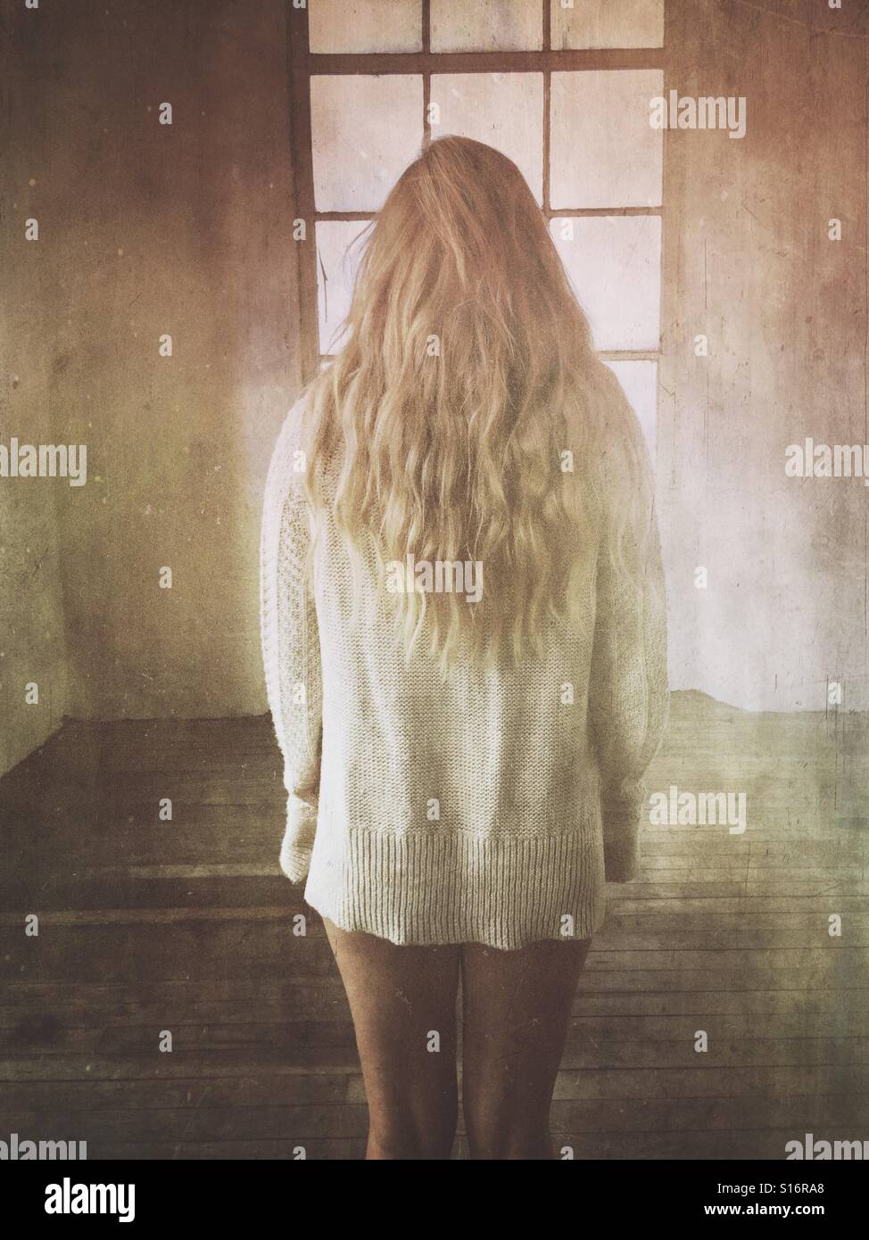 Vue arrière d'une femme blonde par la fenêtre Banque D'Images