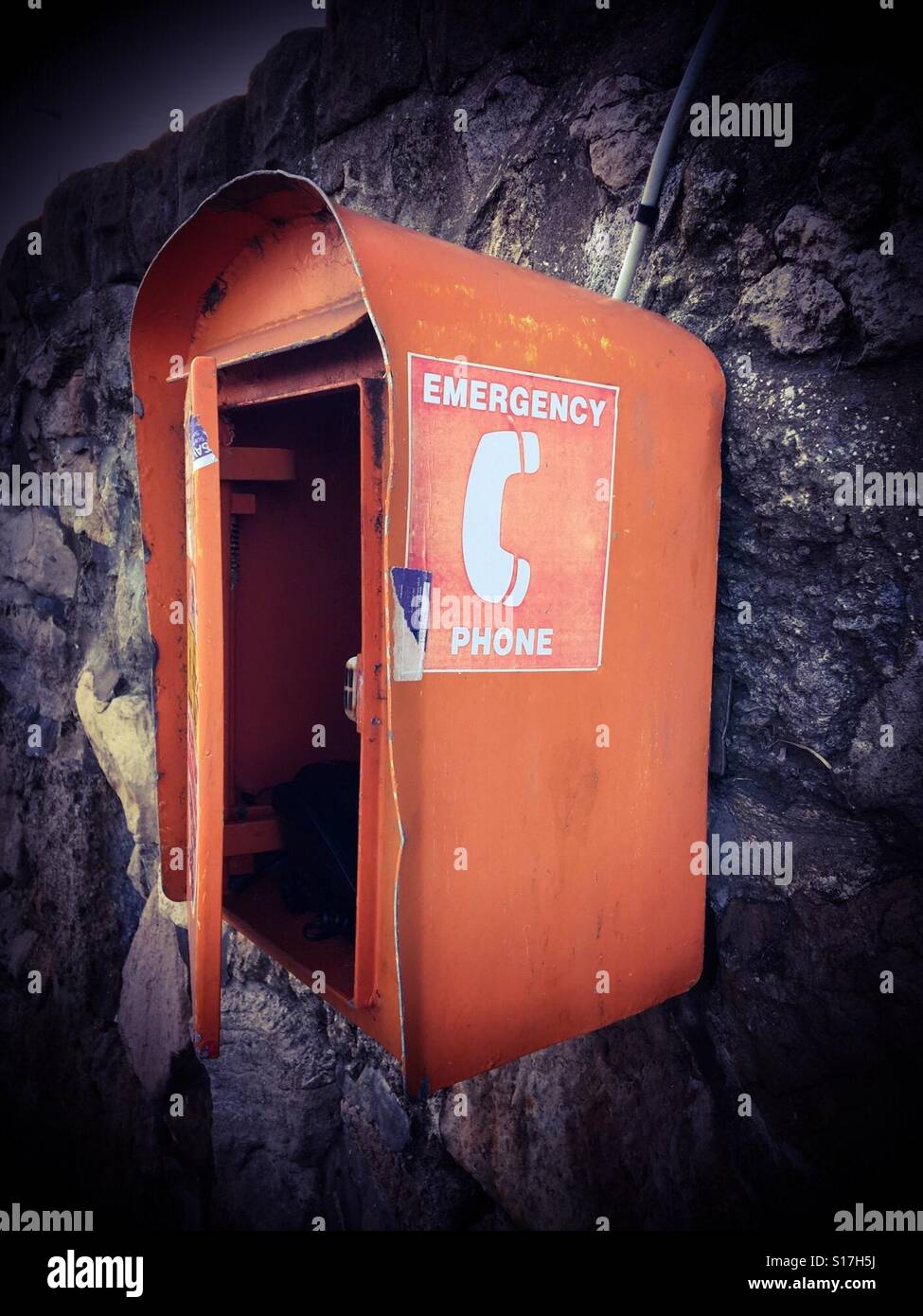 Téléphone d'Orange fort attaché à un mur à l'autre Banque D'Images
