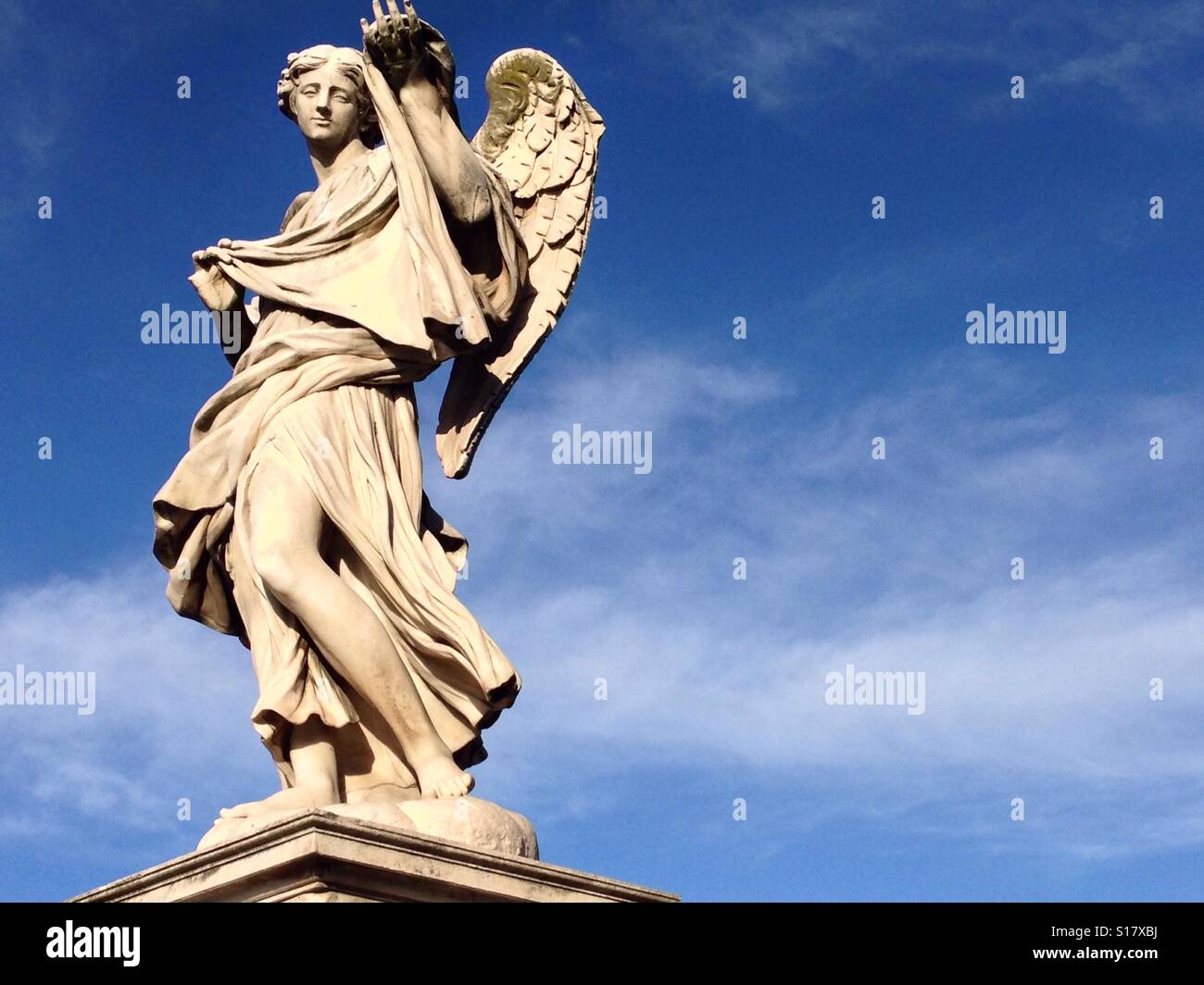 Statue en marbre blanc de l'Ange avec l'Sudarium" sur un fond de ciel bleu avec quelques nuages, le Ponte Sant'Angelo à Rome, Italie. Banque D'Images