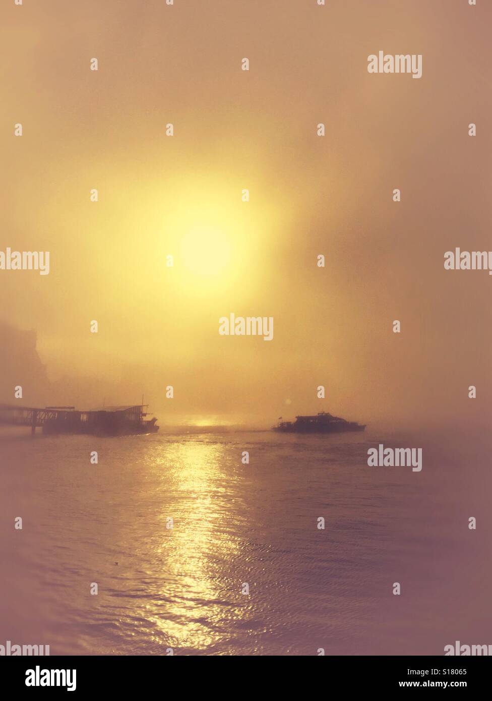 Un bateau lent du voyage avec de lourdes mist sur la Tamise à Londres. Banque D'Images