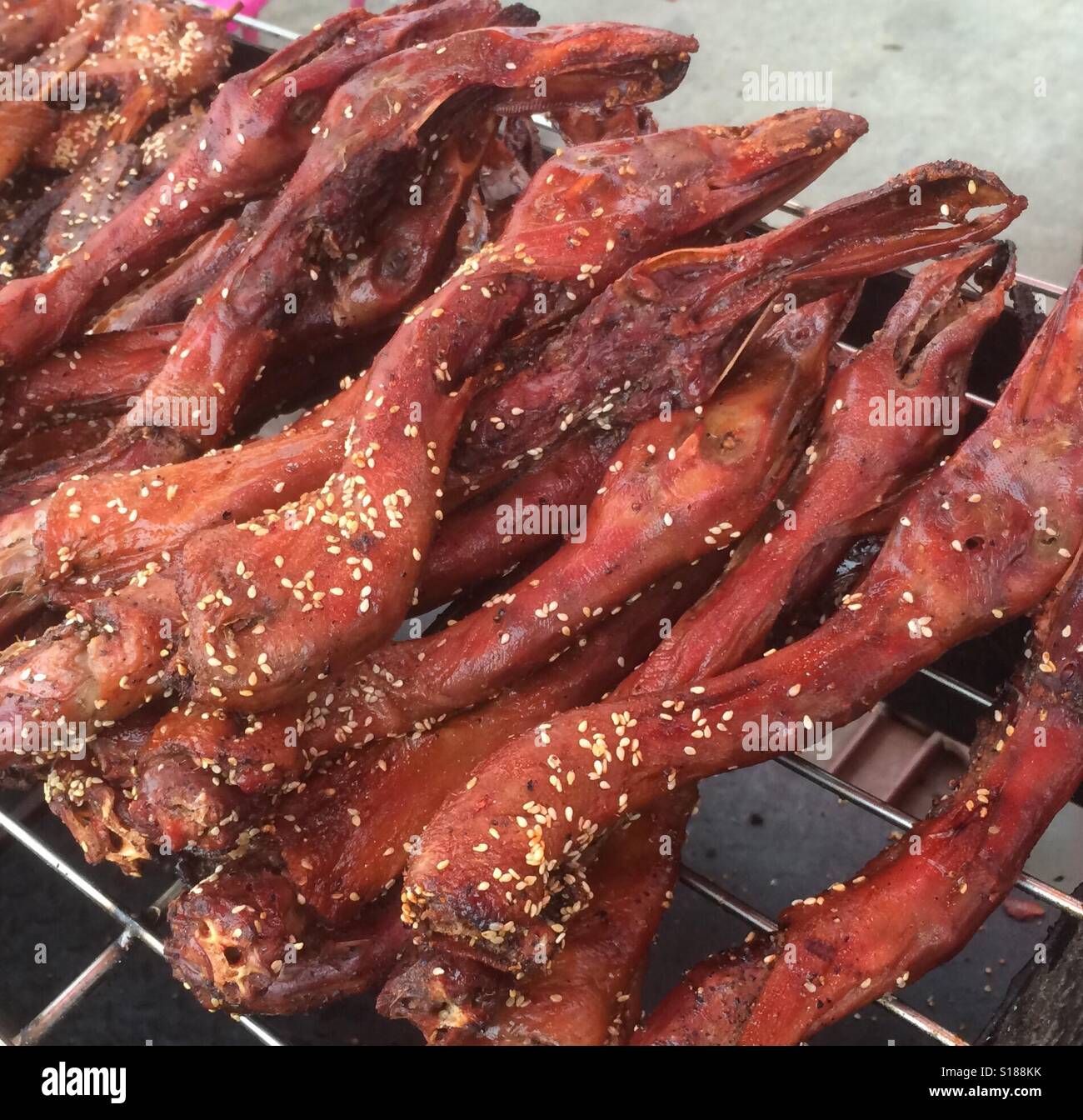 L'alimentation de rue exotiques - cou de canard poêlées enrobées de graines de sésame, Buriram, Thaïlande Banque D'Images