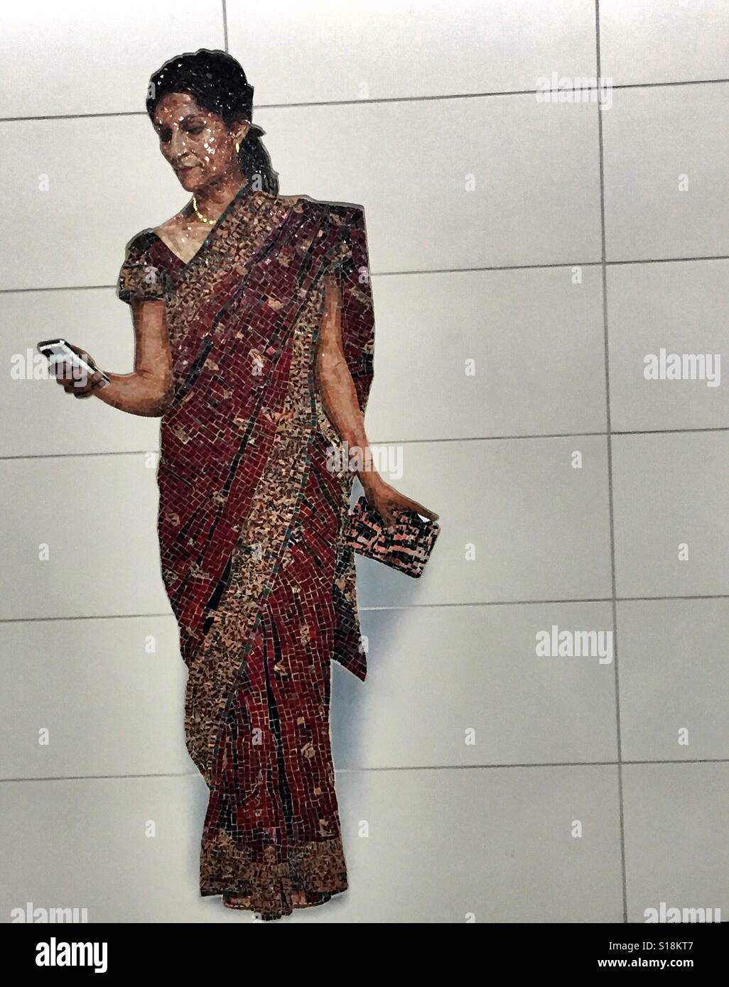 L'art de la mosaïque à nouveau à l'Est de la station de métro 72nd Street, représentant tous les jours New Yorkais. Une femme portant un sari, regardant son téléphone cellulaire. Banque D'Images