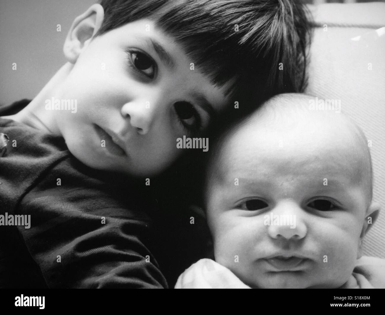Une image en noir et blanc d'une fille et de son petit frère Banque D'Images