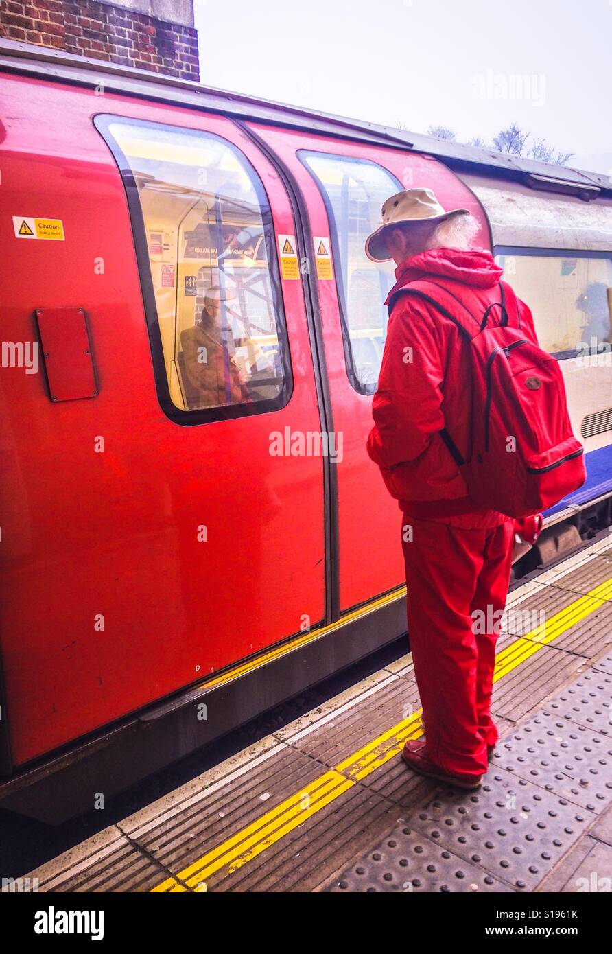 L'homme en rouge attend que les portes du train pour ouvrir Banque D'Images