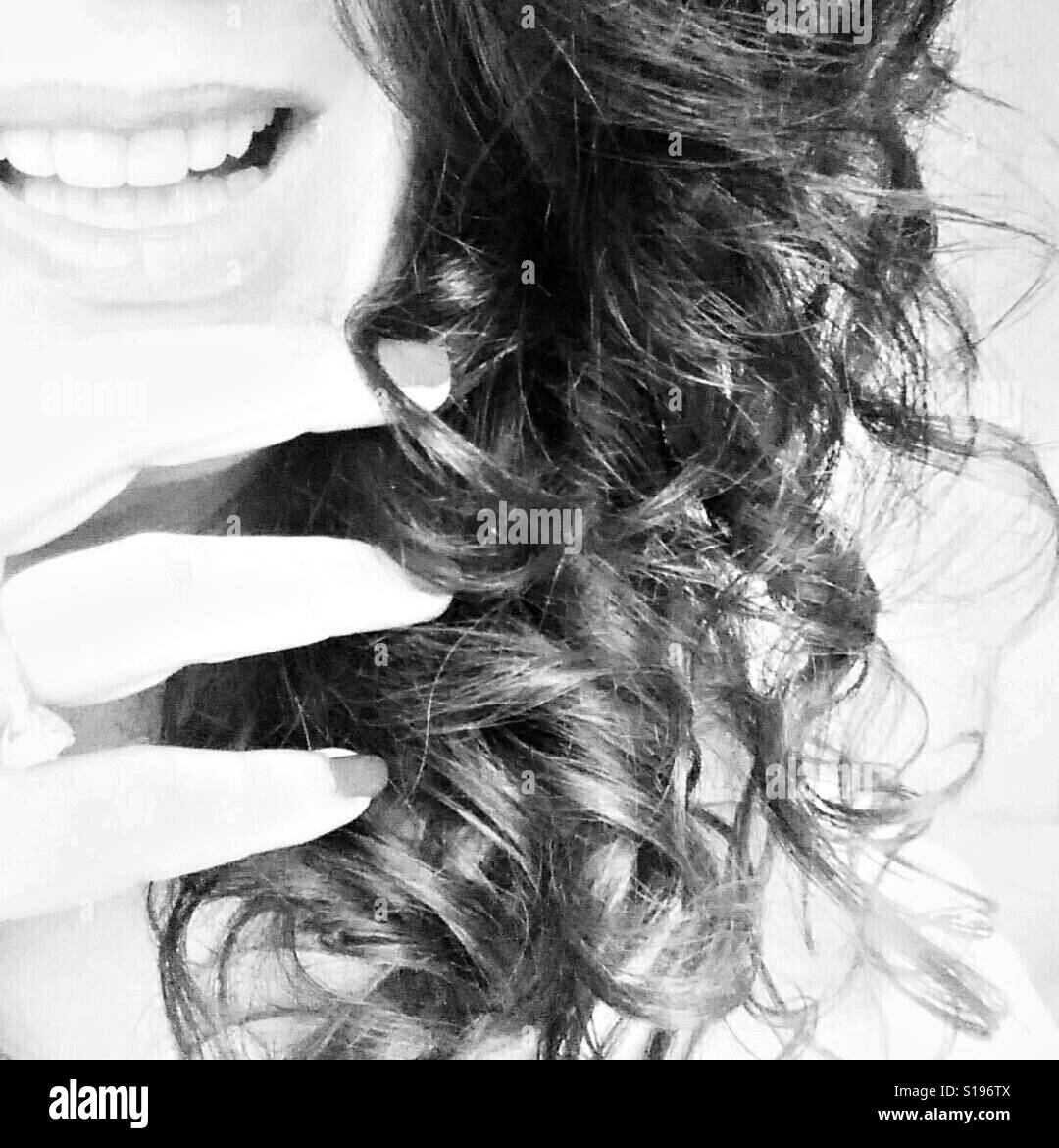 Femme souriante aux cheveux bouclés Banque D'Images