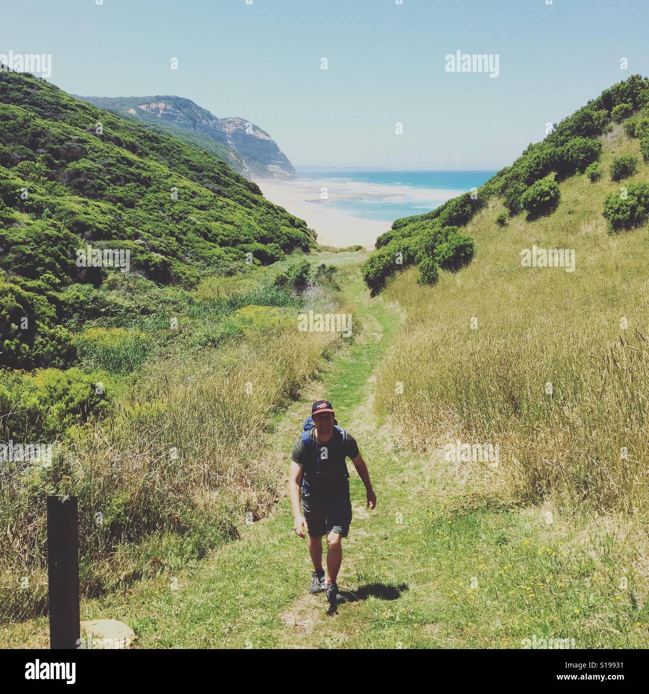 Un randonneur grimpe une colline de la plage sur le Grand Océan à pied à Victoria en Australie Banque D'Images