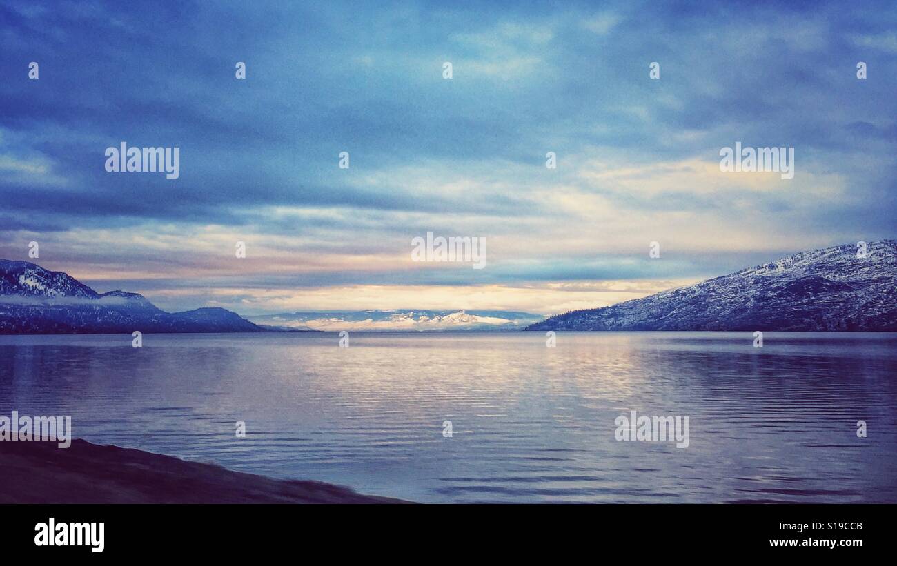 Paysage d'hiver de lac entouré de montagnes enneigées sous un ciel nuageux - Image de stock capturée avec un smartphone
