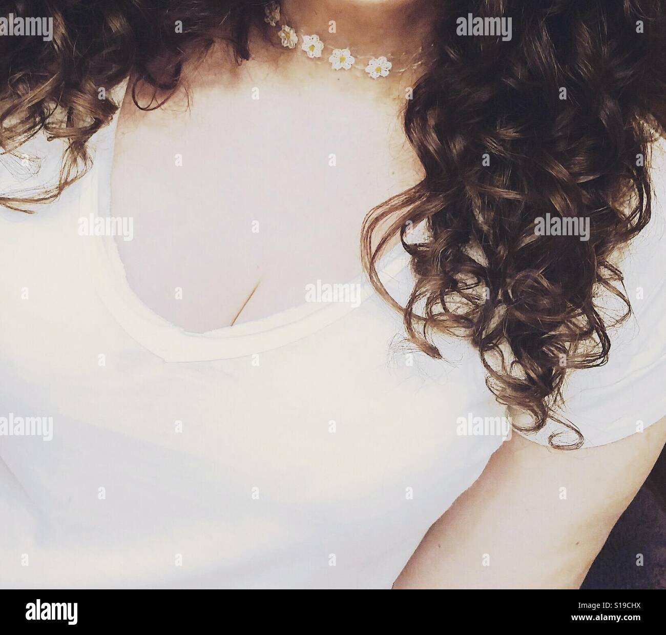 Curly Haired Woman Wearing Daisy Collier Banque D'Images