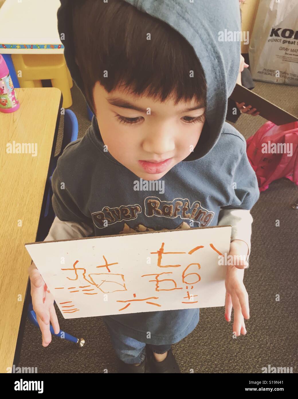 Garçon apprend à écrire des caractères chinois à l'école. Banque D'Images