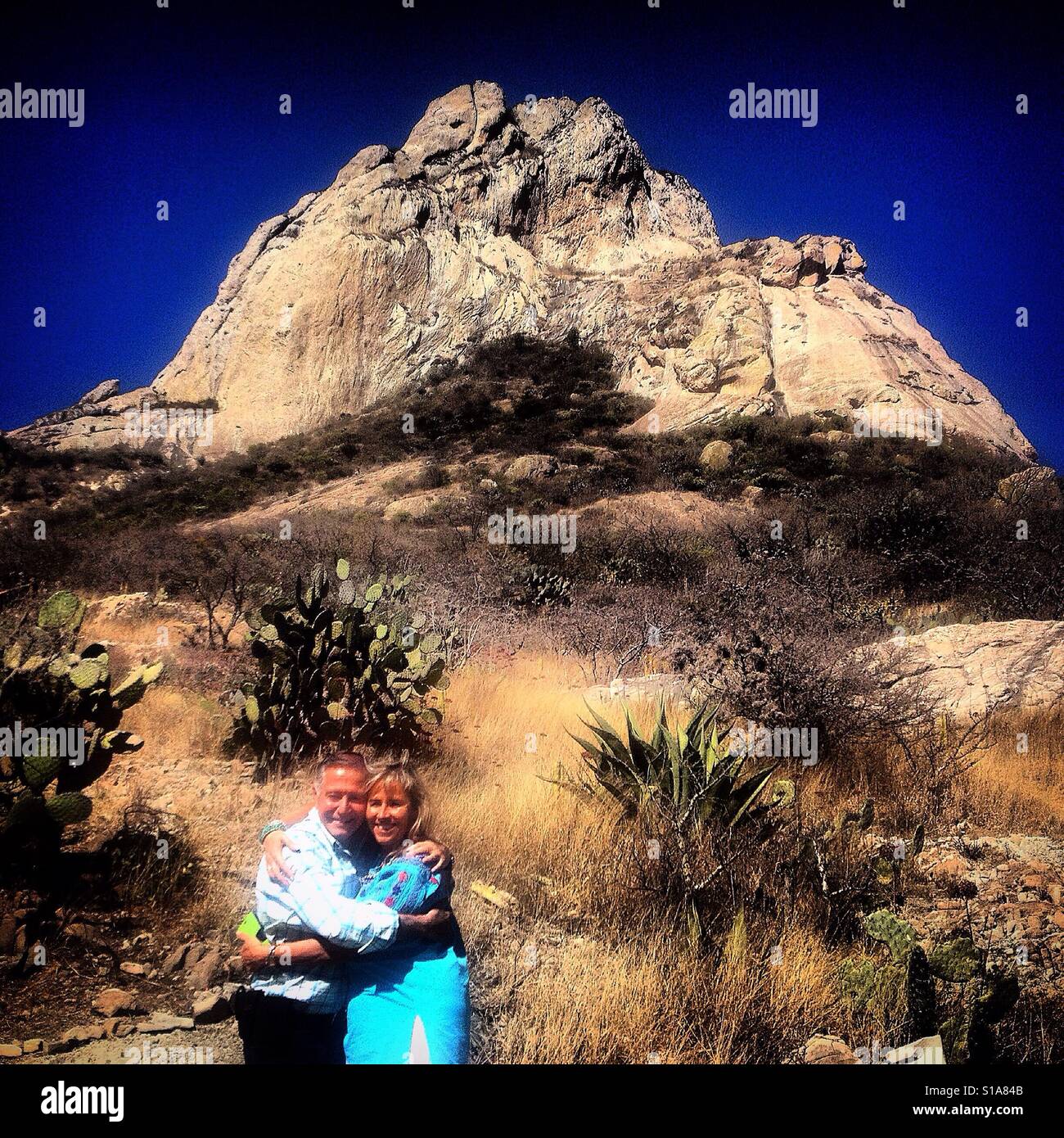 Un couple s'embrassent dans l'avant de la Peña de Bernal monolite mountain à San Sebastian Bernal à Queretaro, Mexique Banque D'Images