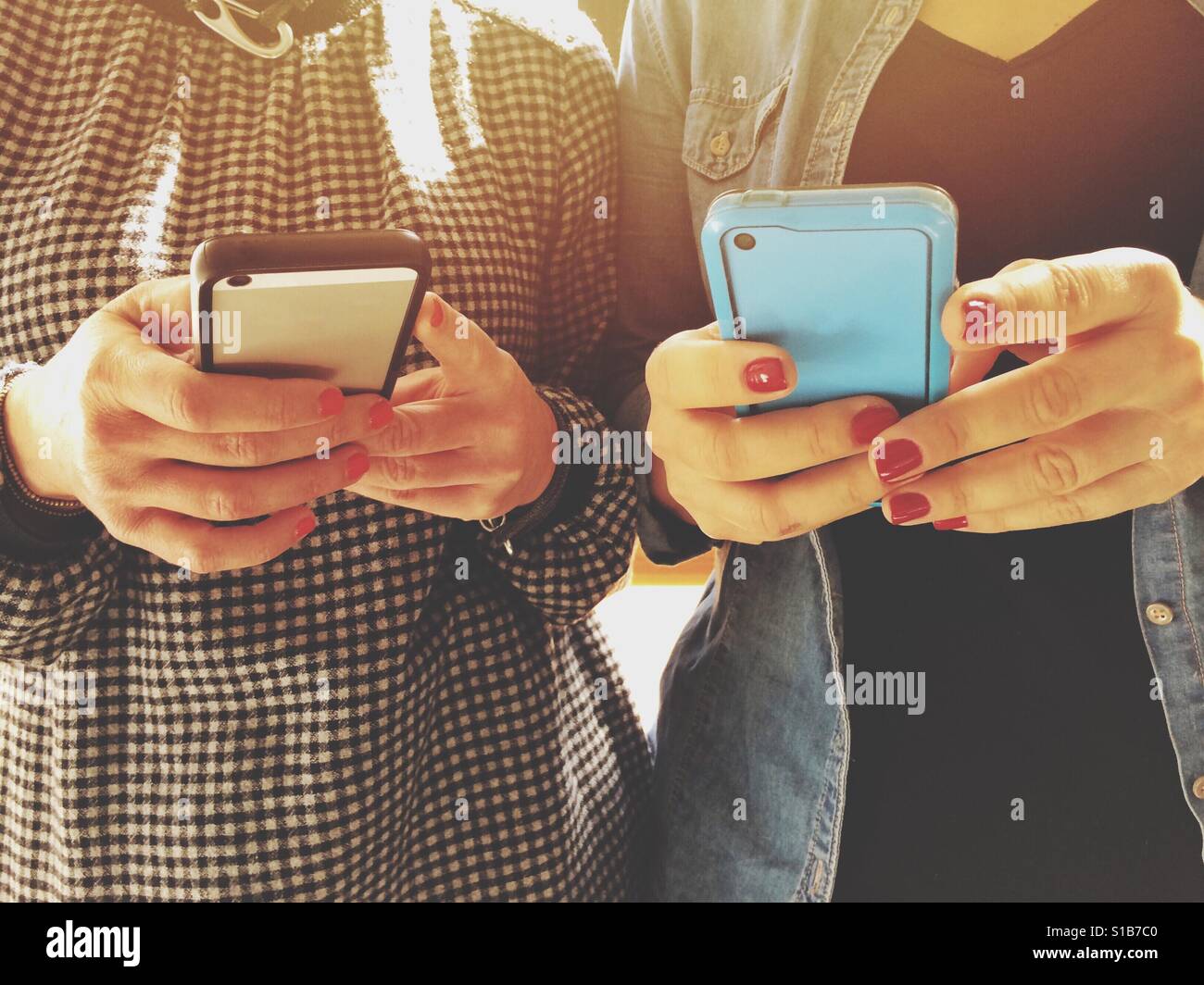 Les femmes utilisant les téléphones mobiles Banque D'Images