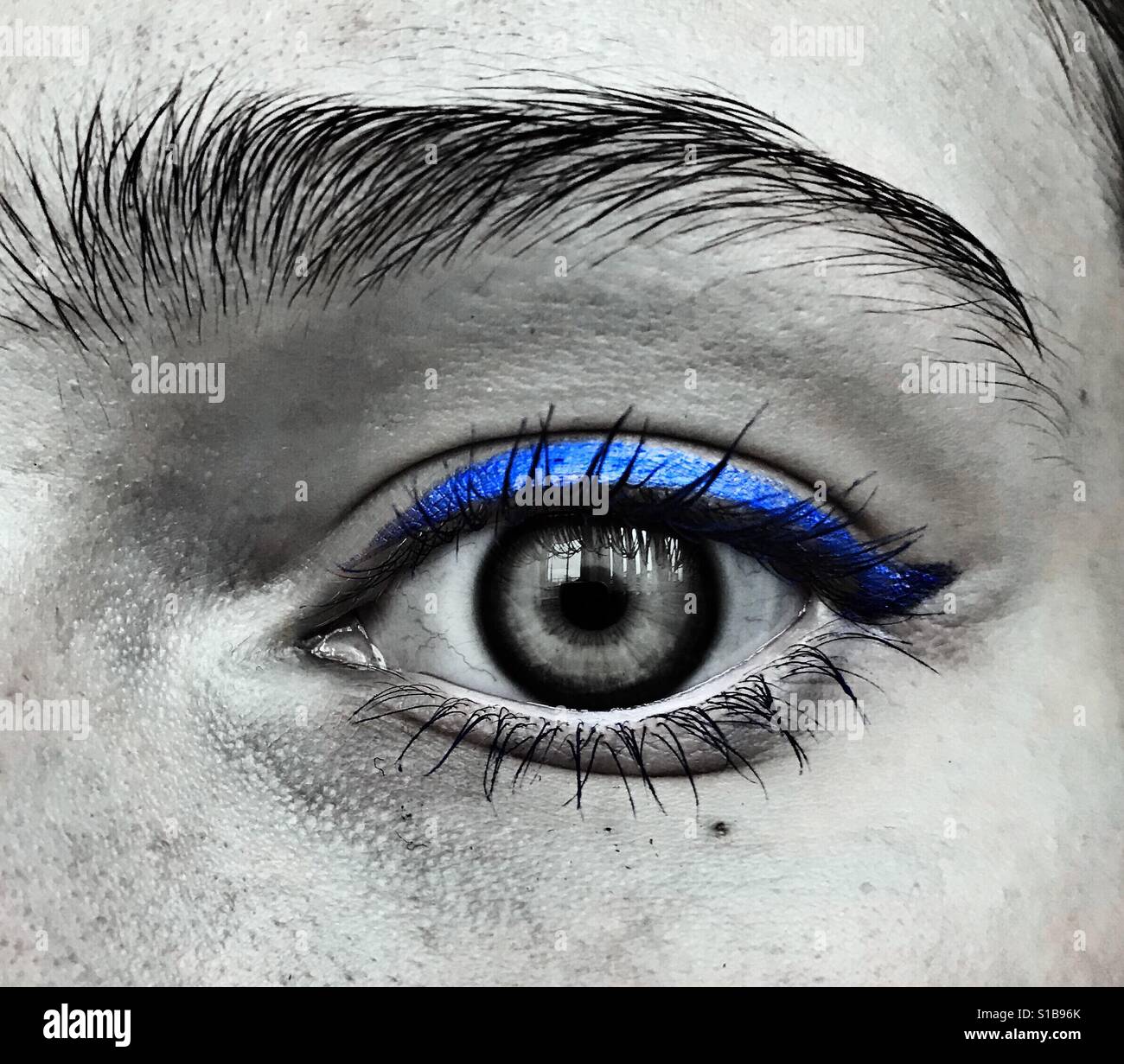Un noir et blanc gros plan d'un oeil avec l'eyeliner bleu Banque D'Images