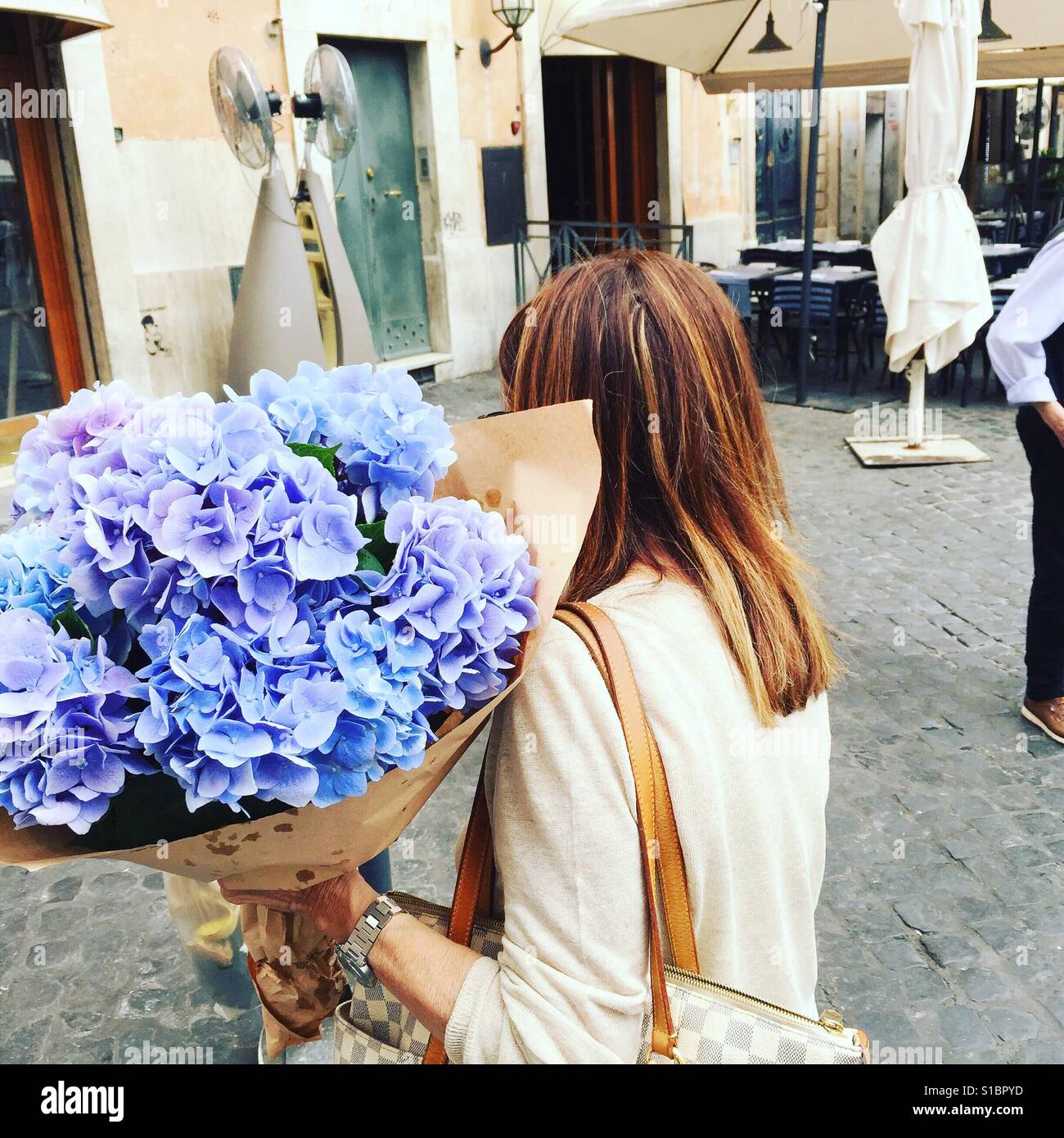 Dame transportant des fleurs lilas Banque D'Images