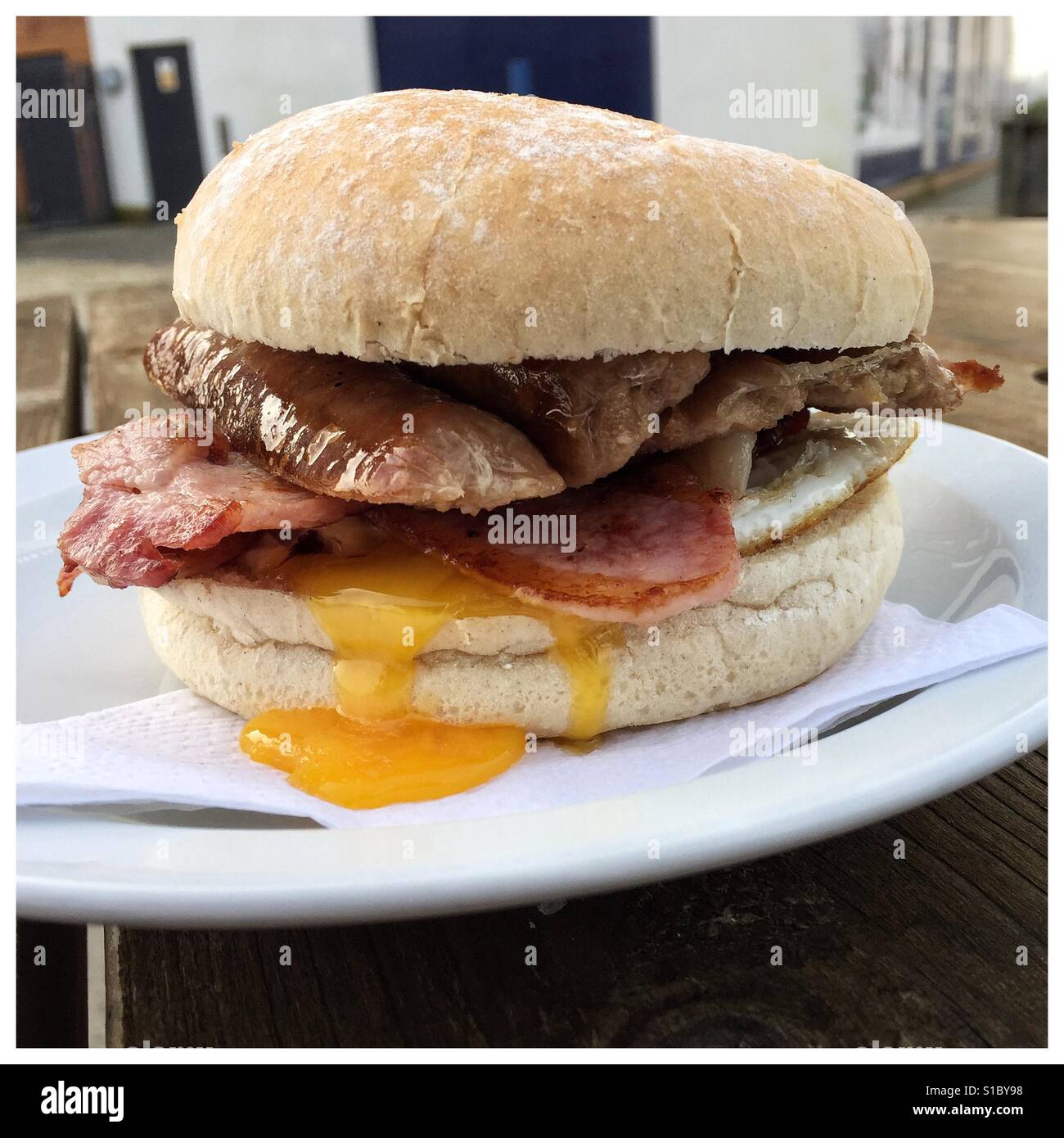 Un délicieux petit-déjeuner pab/rouleau d'un café en plein air remplie de bacon, saucisses et œufs. Riche en cholestérol et en gras ce n'est pas une option petit-déjeuner sain Banque D'Images