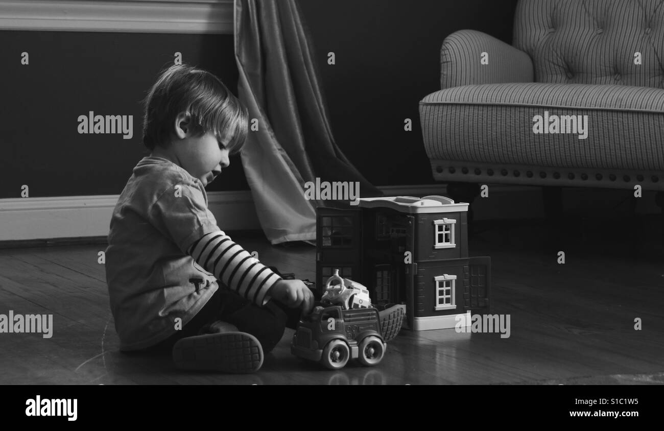 Jeune bambin boy playing with toy cars à l'intérieur à la maison Banque D'Images