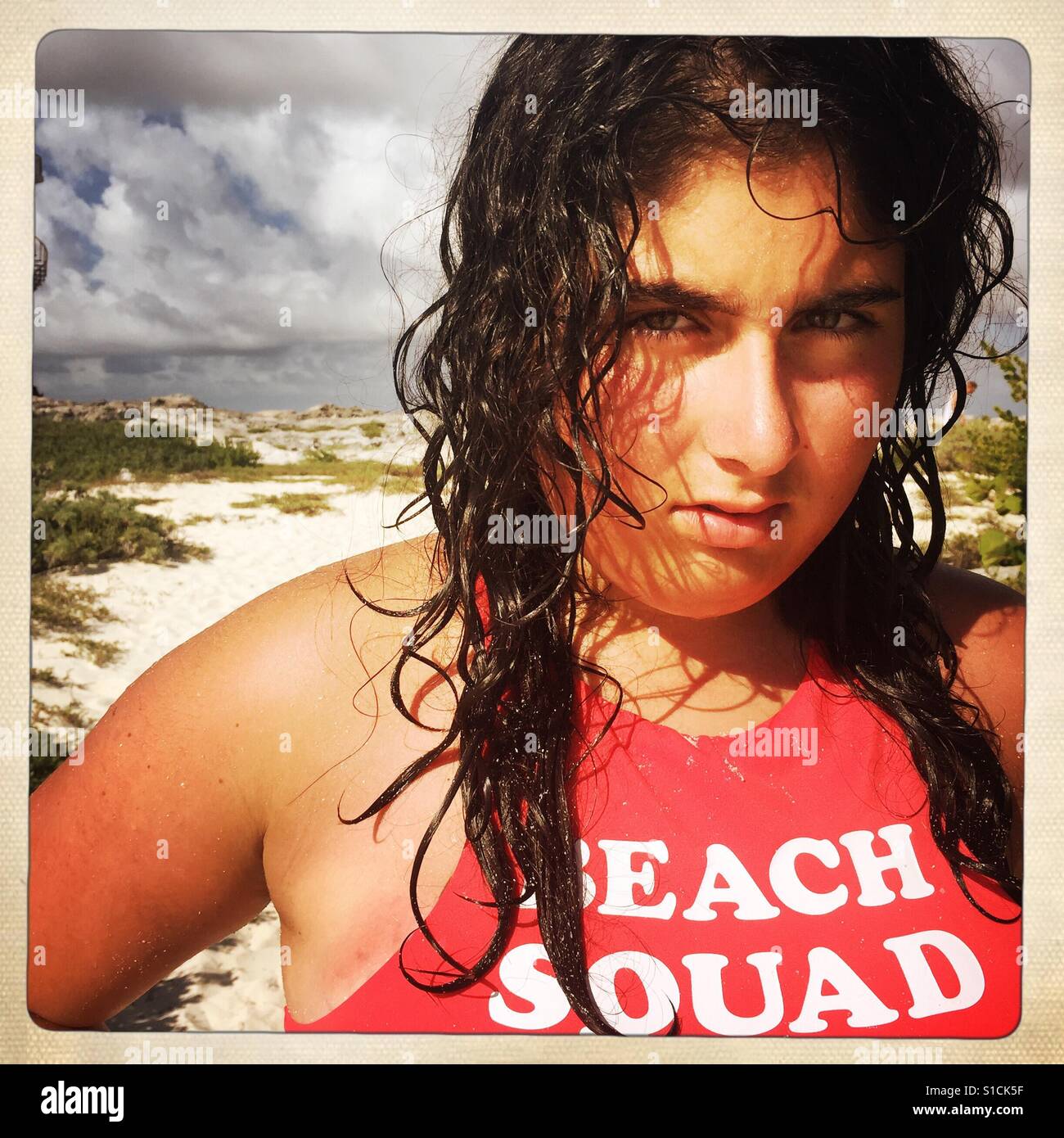 Jeune fille avec de longs cheveux mouillés sur une plage avec red bikini top Banque D'Images