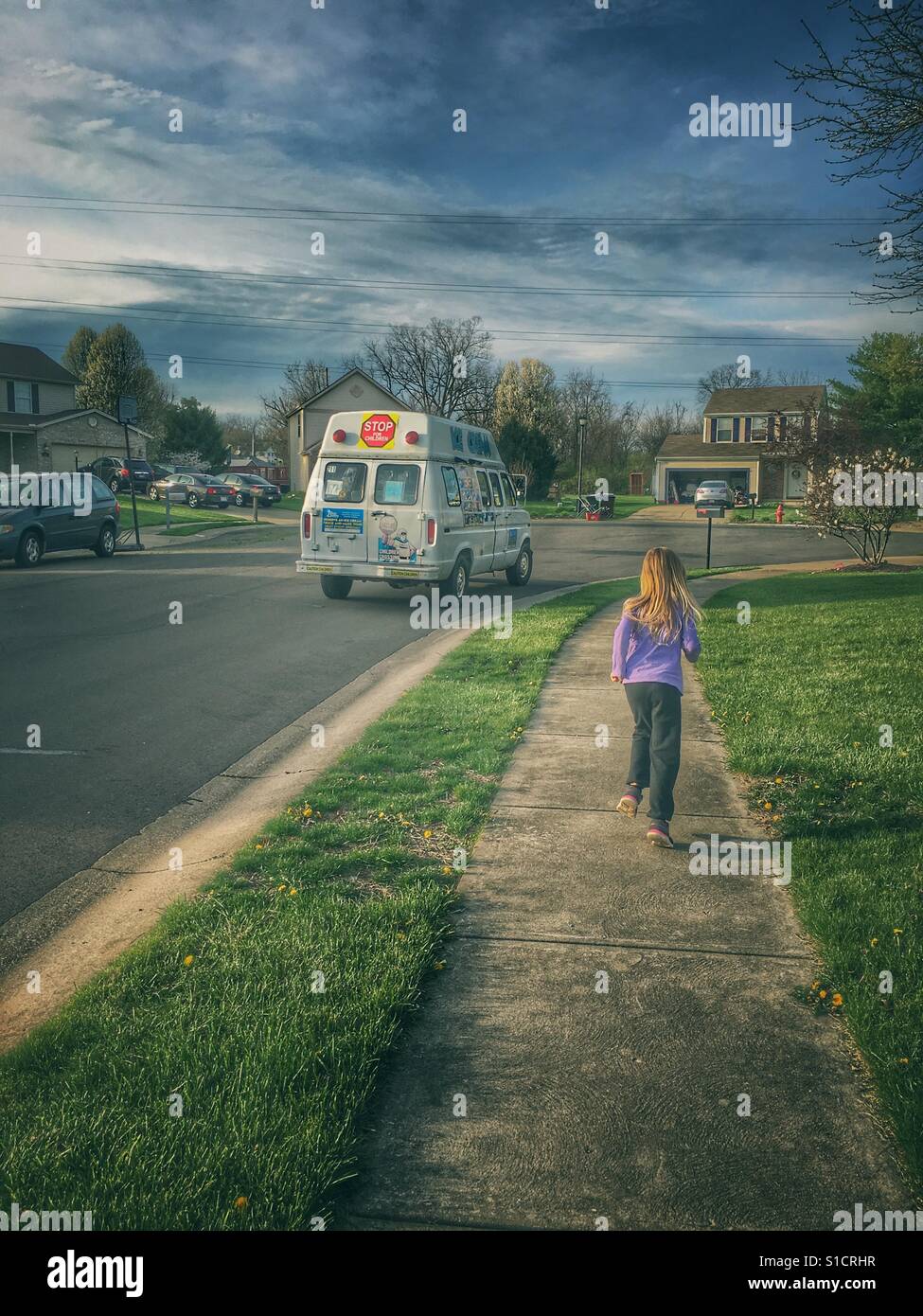 Un signe certain que l'été est sur son chemin ; l'enfant courir après un camion de crème glacée. Banque D'Images