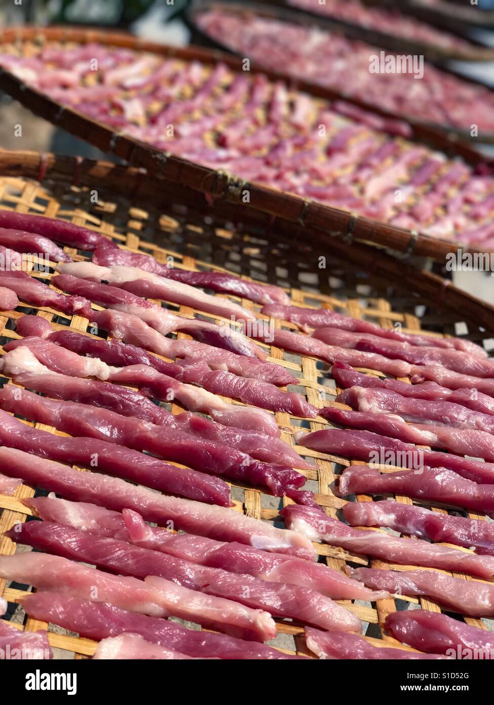 Conserves de porc séchées au soleil sur panier de bambou Banque D'Images