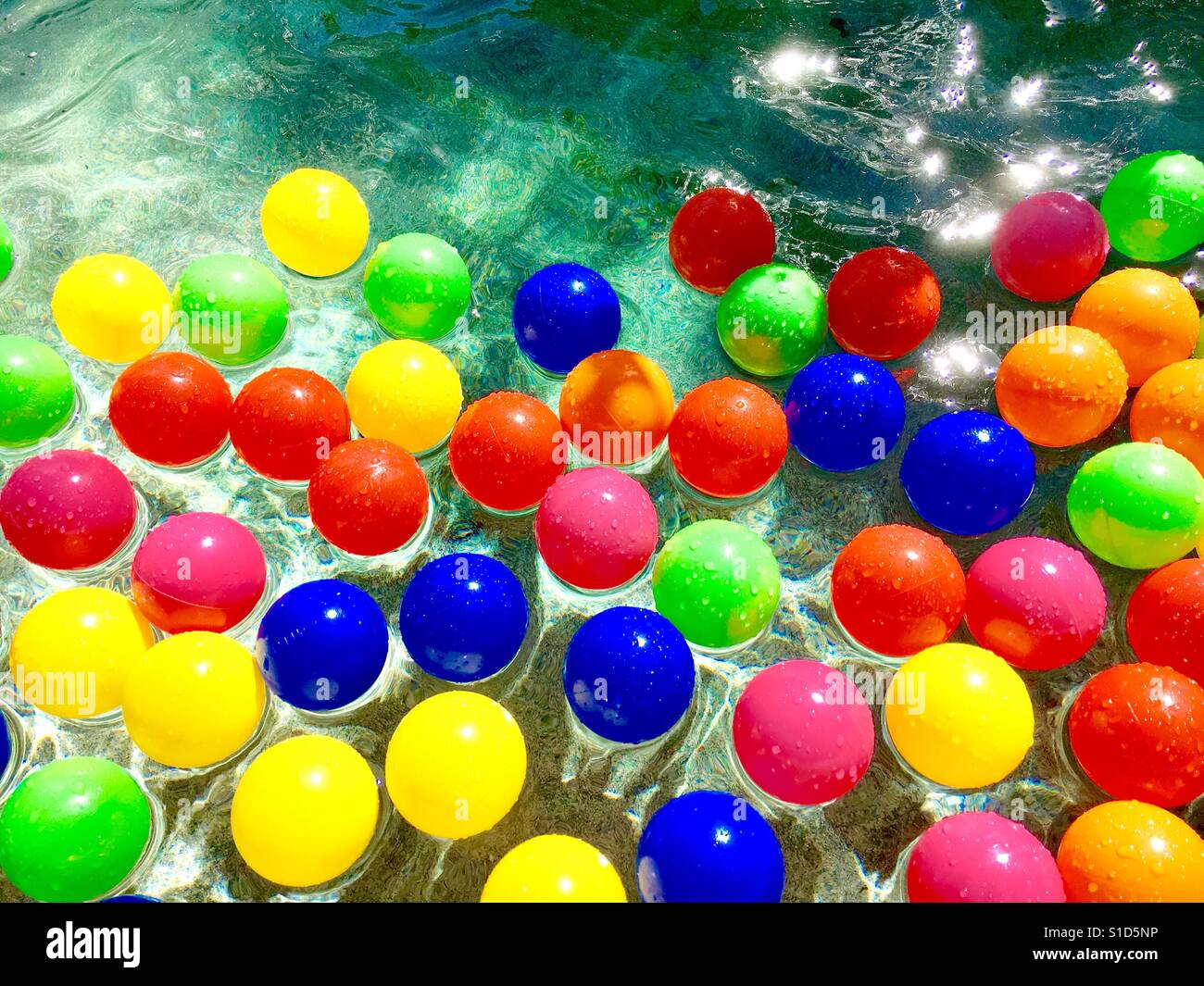 Billes en plastique coloré flottant sur l'eau Banque D'Images