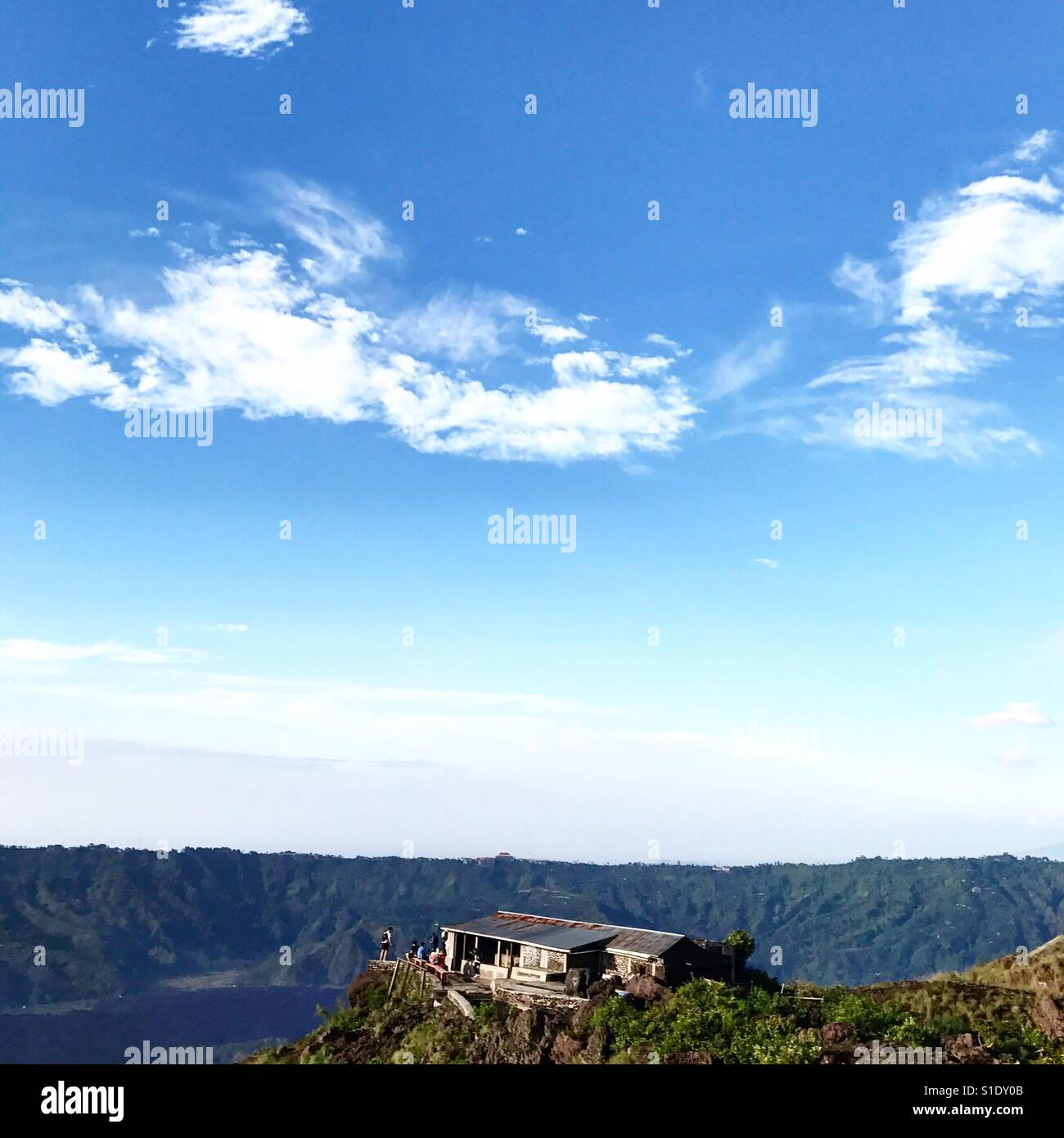 Une façon station au sommet d'une montagne, sous un ciel bleu avec les nuages minces Banque D'Images