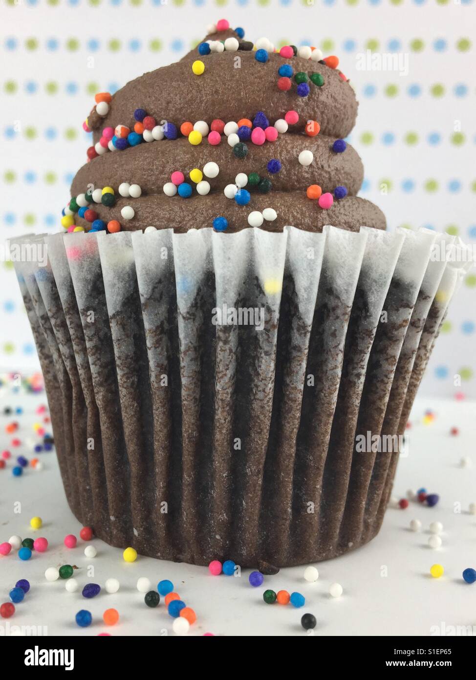 Cupcake au chocolat avec glaçage au chocolat bonbons et paillettes. Banque D'Images