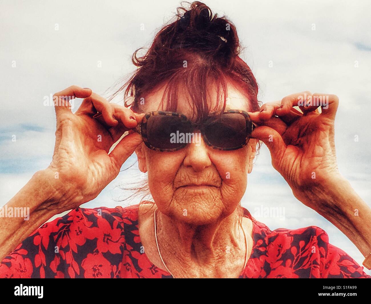 80-ans femme britannique ajuster ses lunettes de - Image de stock capturée avec un smartphone