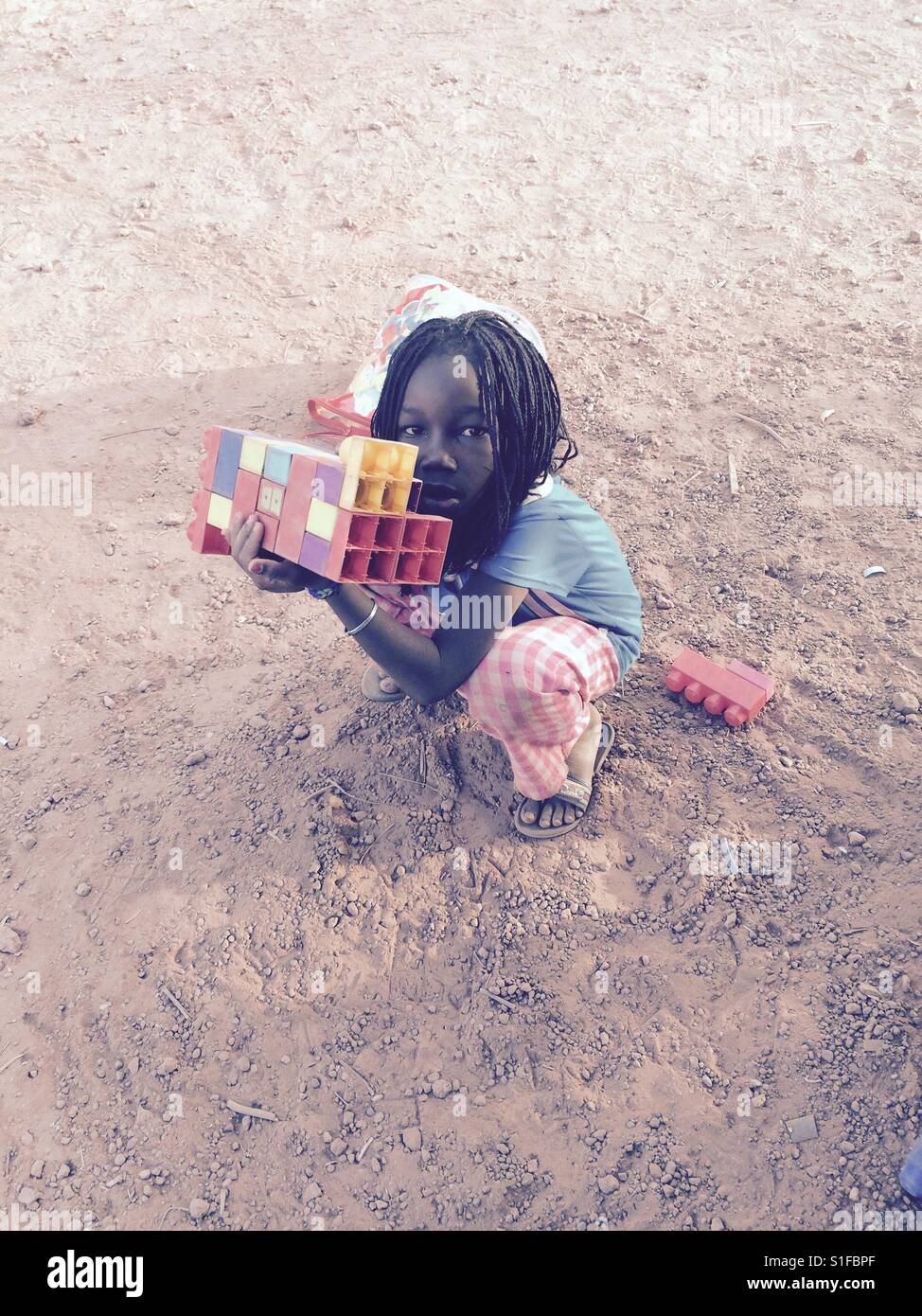 Un enfant joue avec des legos au Burkina Faso, Afrique. Banque D'Images