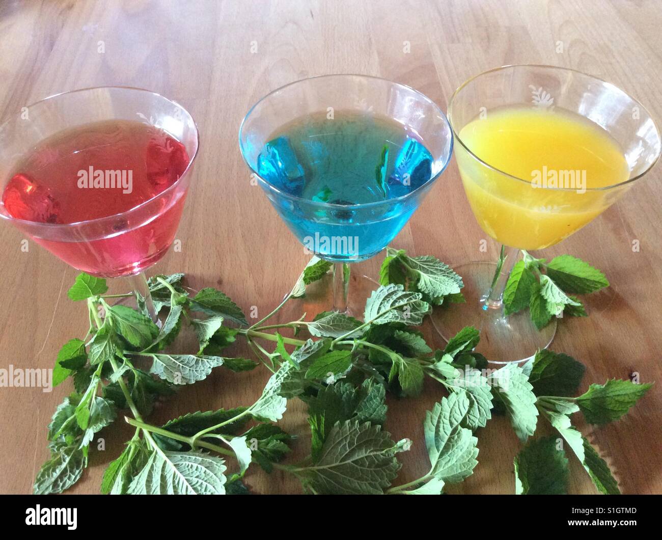 Des boissons dans des couleurs arc-en-ciel et de citron sur la table palm Banque D'Images