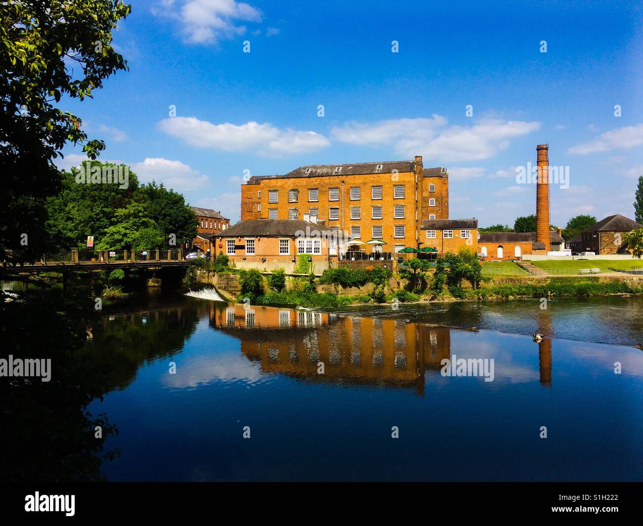 Darley Abbey Mill reflétée dans la rivière Derwent Derby England UK Banque D'Images