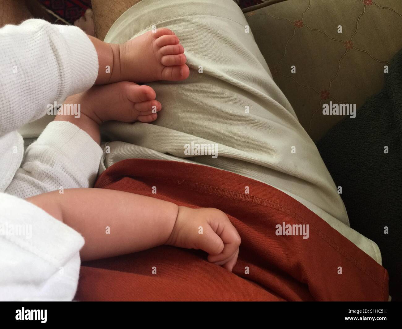 Une main de deux pieds. Un bébé couché contentement sur un adulte, les deux probablement endormi. Doux, doux, contentement. Non planifié. Impromptu. C'est arrivé. - Image de stock capturée avec un smartphone